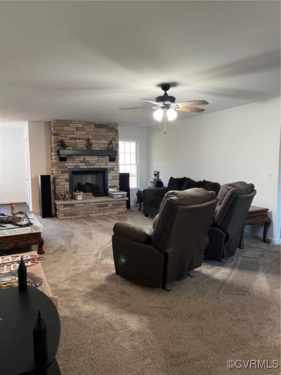 carpeted living room featuring a fireplace and a ceiling fan