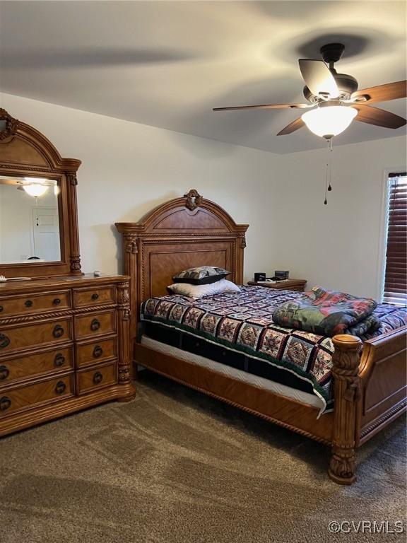 bedroom featuring dark colored carpet and a ceiling fan