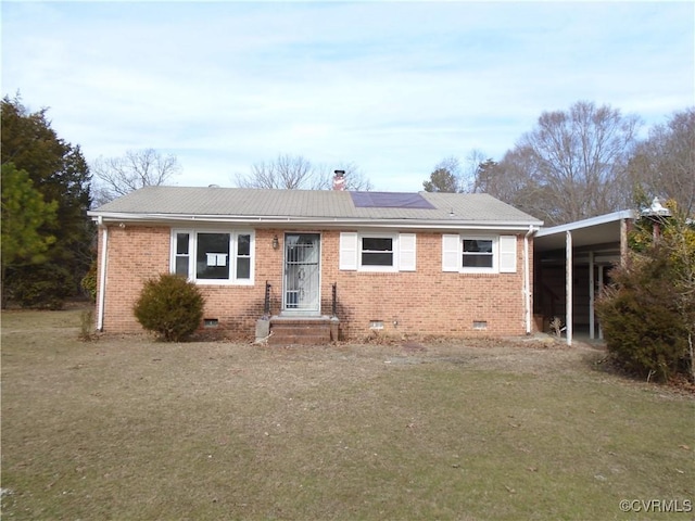 view of front of home with brick siding, a chimney, solar panels, a front yard, and crawl space