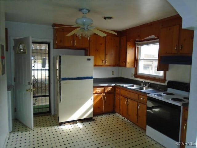 kitchen featuring electric stove, light floors, a sink, and freestanding refrigerator