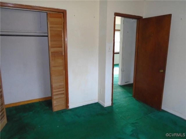 unfurnished bedroom with a closet, carpet flooring, and baseboards