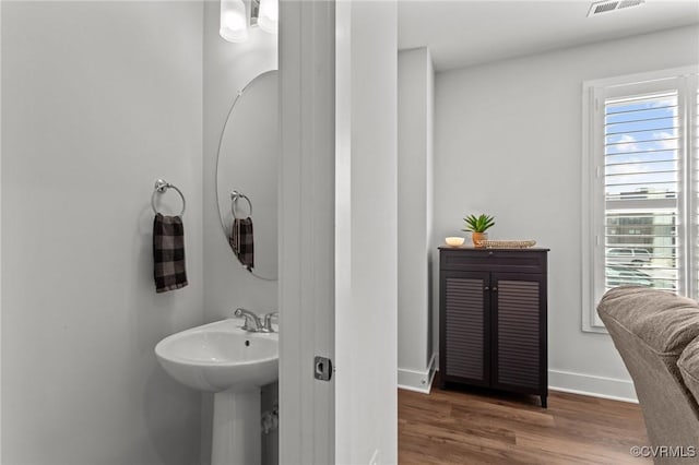 bathroom with visible vents, baseboards, and wood finished floors