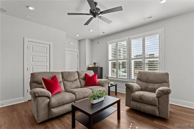 living area with wood finished floors, visible vents, and recessed lighting