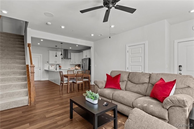 living room featuring ceiling fan, recessed lighting, wood finished floors, baseboards, and stairway