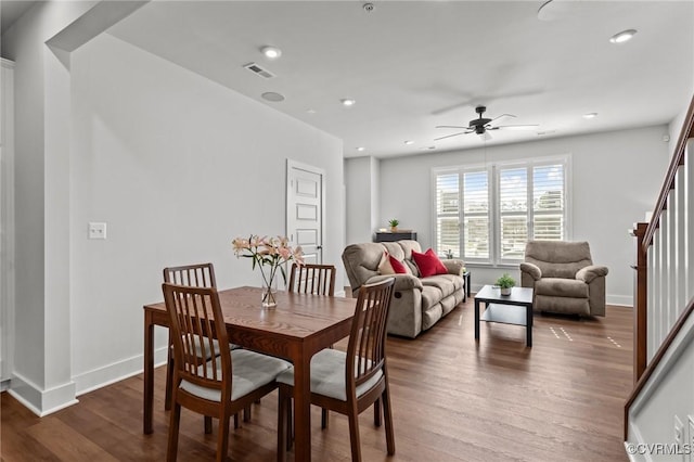 dining room featuring recessed lighting, wood finished floors, visible vents, baseboards, and stairs