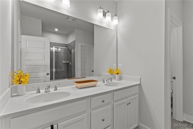 bathroom featuring double vanity, a sink, and a shower stall