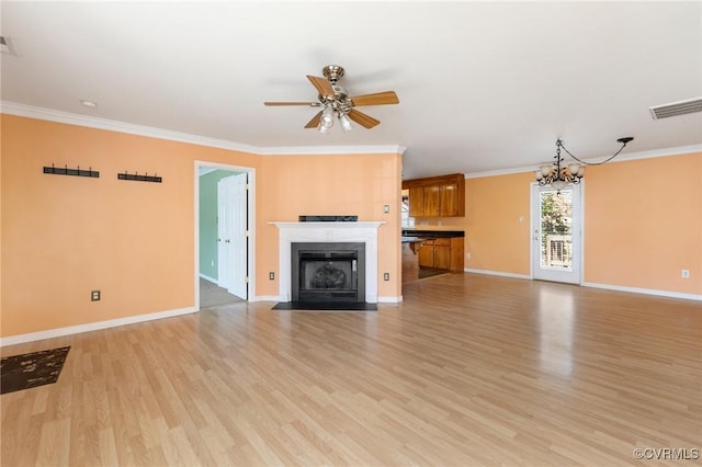 unfurnished living room with light wood finished floors, a fireplace with flush hearth, visible vents, and crown molding