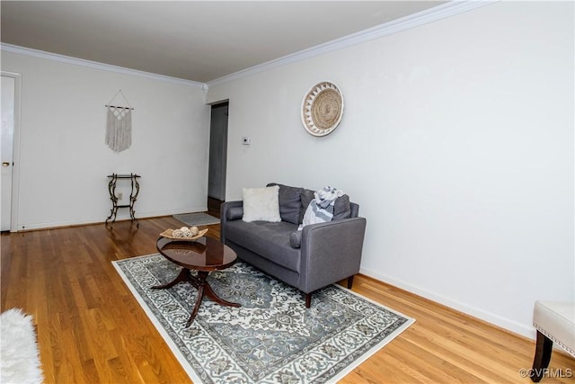 living area featuring baseboards, ornamental molding, and wood finished floors