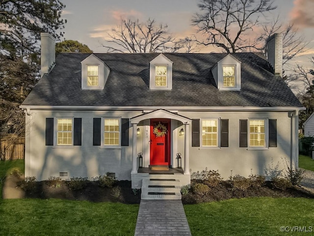 cape cod house with crawl space, a chimney, and brick siding