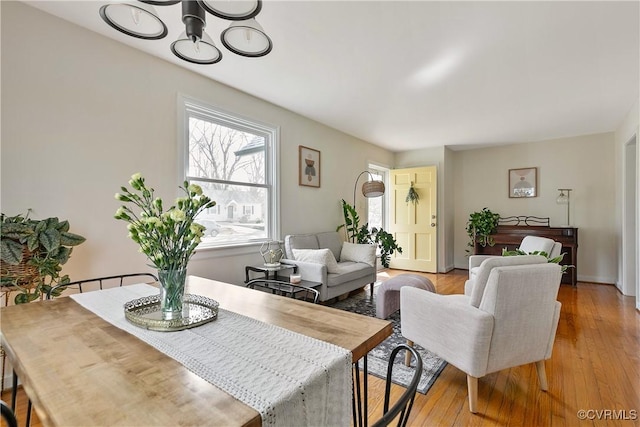 dining room featuring light wood-type flooring and an inviting chandelier