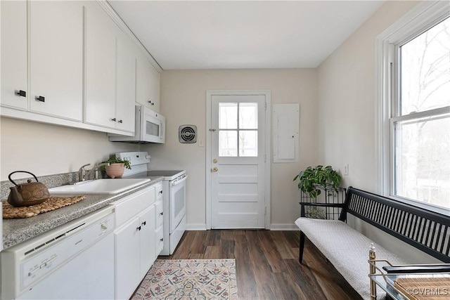 kitchen with white appliances, dark wood-type flooring, a sink, white cabinets, and light countertops