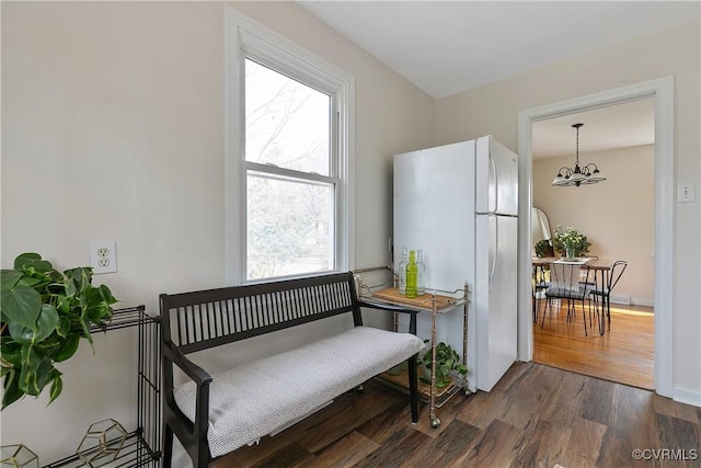 interior space with an inviting chandelier, baseboards, and dark wood-style flooring