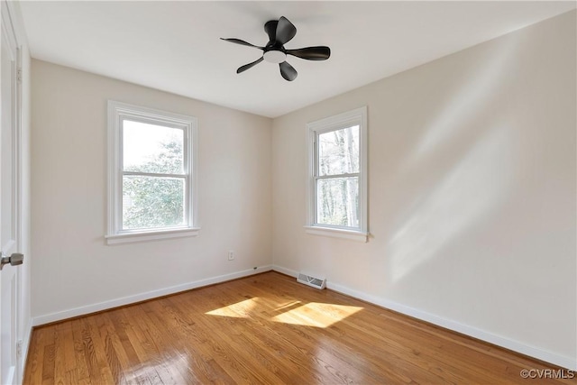 unfurnished room featuring plenty of natural light, light wood finished floors, baseboards, and visible vents