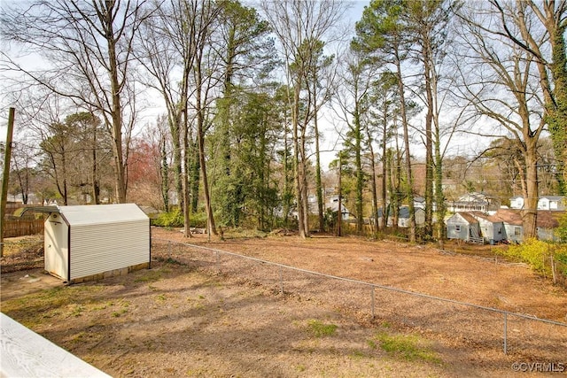 view of yard with a storage unit, fence, and an outdoor structure