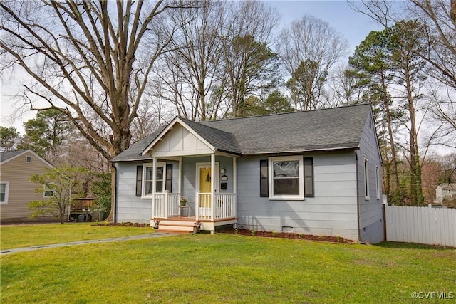 view of front of home featuring a shingled roof, crawl space, fence, and a front lawn