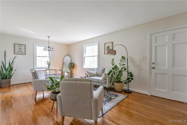 living room with baseboards, a healthy amount of sunlight, and light wood finished floors