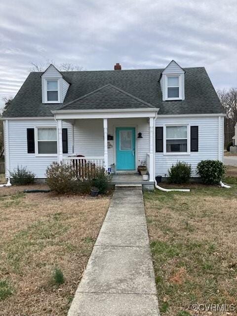 cape cod home with a front lawn, a shingled roof, and a porch
