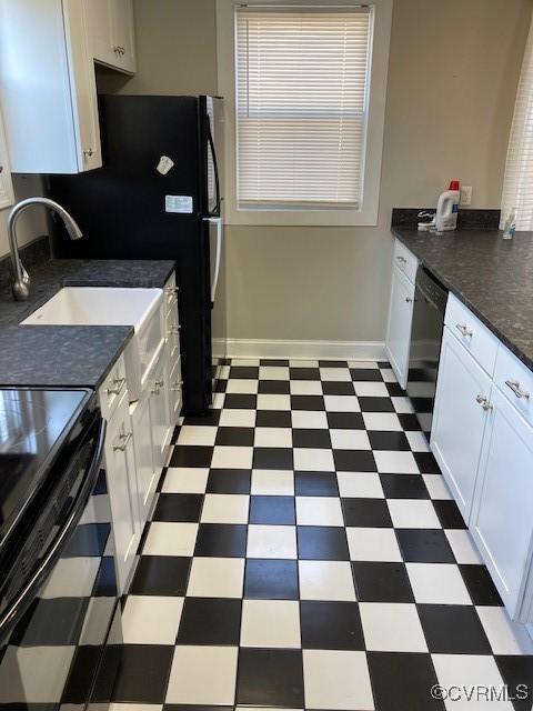 kitchen with white cabinets, tile patterned floors, baseboards, and dark countertops