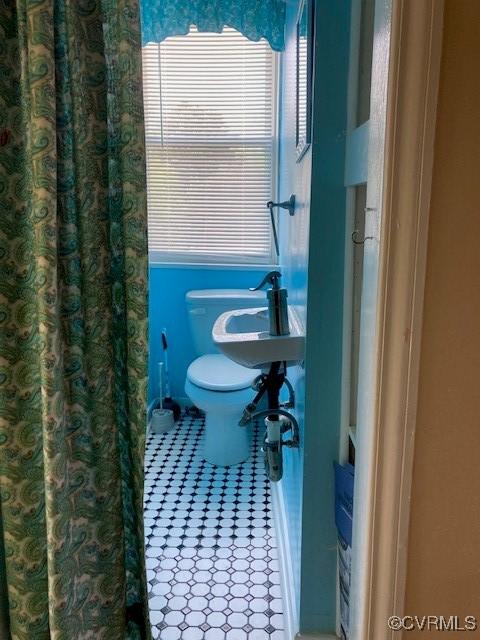 bathroom with toilet and tile patterned floors