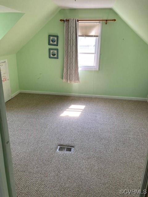 bonus room with visible vents, lofted ceiling, and carpet floors