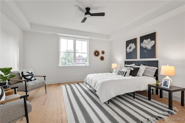 bedroom featuring light wood-type flooring, a ceiling fan, and baseboards