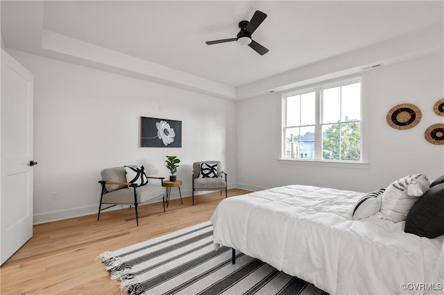 bedroom featuring baseboards, ceiling fan, visible vents, and light wood finished floors