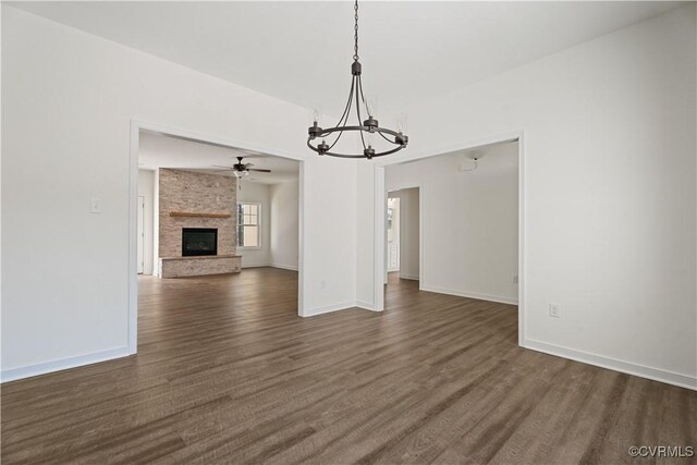 11777 Pine Needles Dr, New Kent, VA 23140 - unfurnished living room with a chandelier, dark wood-style flooring, a brick fireplace, and baseboards