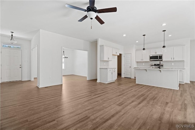 11777 Pine Needles Dr, New Kent, VA 23140 - unfurnished living room featuring a ceiling fan, wood finished floors, recessed lighting, and baseboards