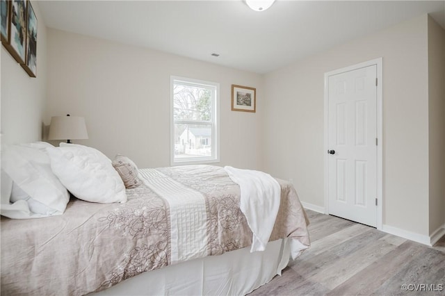 bedroom featuring baseboards and wood finished floors