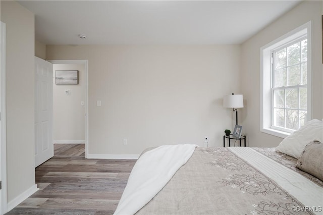 bedroom with wood finished floors and baseboards