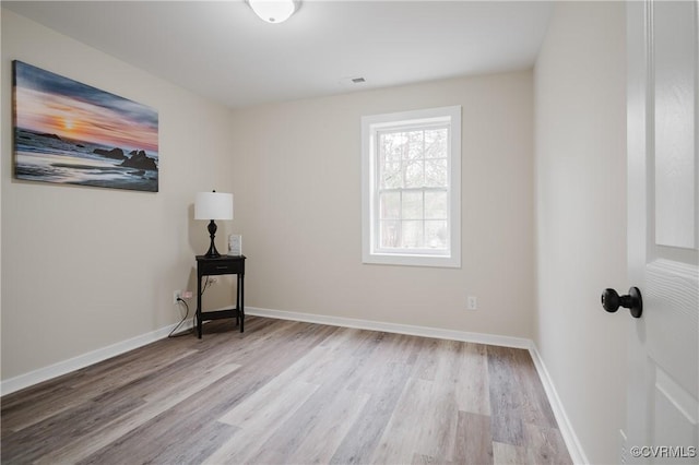 interior space with visible vents, baseboards, and wood finished floors