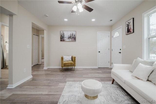 living room featuring a ceiling fan, recessed lighting, light wood-style flooring, and baseboards