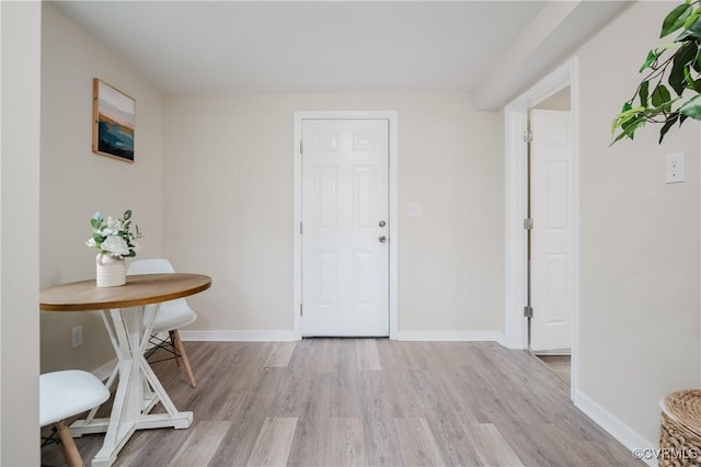 entrance foyer featuring light wood-type flooring and baseboards