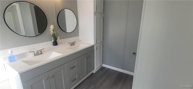 bathroom with double vanity, wood finished floors, and a sink