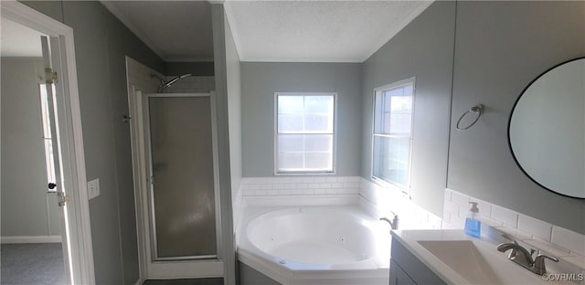 bathroom with a stall shower, vanity, a tub with jets, and a textured ceiling