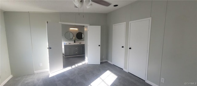 unfurnished bedroom featuring a sink, ensuite bath, and carpet flooring