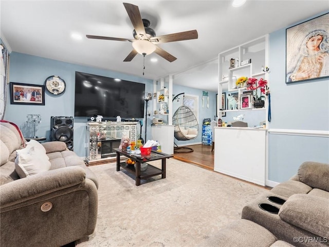 living room featuring recessed lighting, ceiling fan, wood finished floors, and a glass covered fireplace