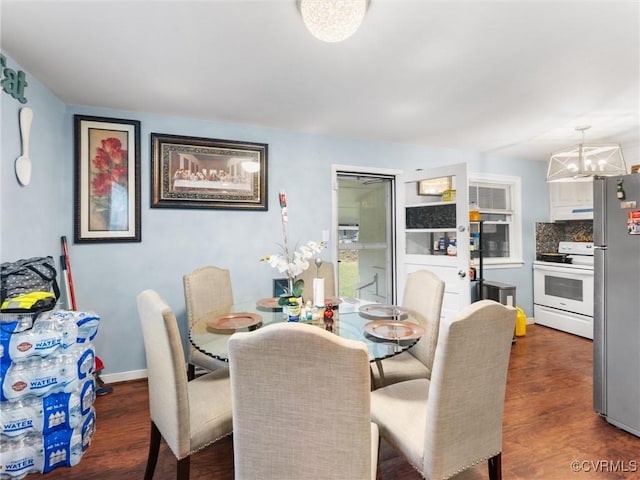 dining area featuring baseboards, a chandelier, and dark wood-style flooring