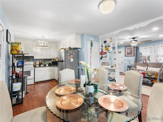 dining space featuring ceiling fan and dark wood-type flooring