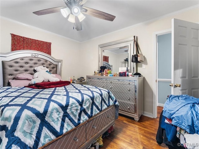 bedroom with ceiling fan, baseboards, wood finished floors, and crown molding