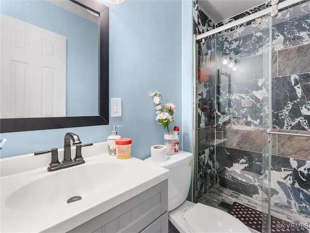 full bathroom with vanity, a shower stall, and toilet