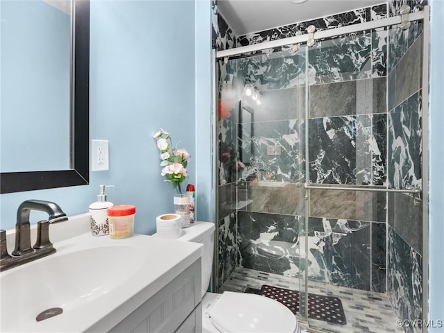 full bathroom with a stall shower, vanity, and toilet