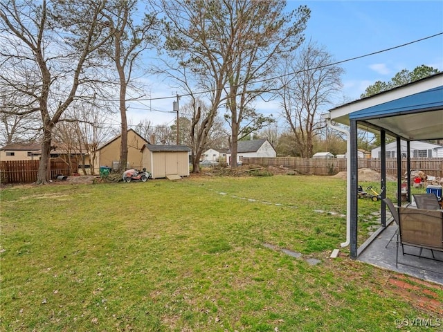 view of yard featuring an outbuilding, a storage unit, and a fenced backyard