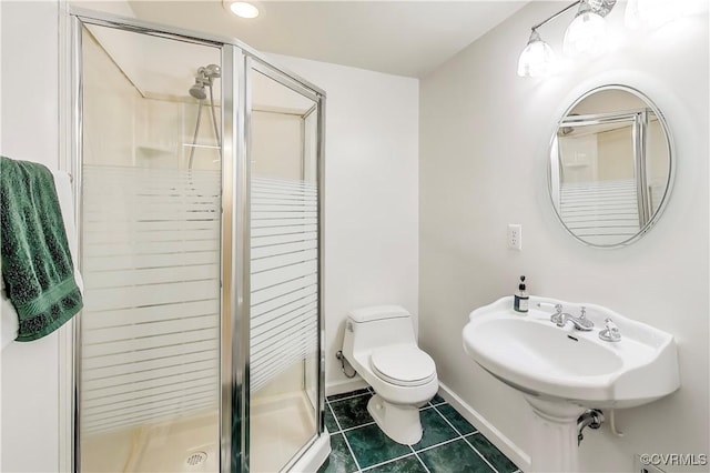 full bathroom featuring tile patterned flooring, toilet, a sink, baseboards, and a shower stall