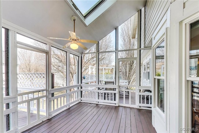 unfurnished sunroom featuring vaulted ceiling with skylight and ceiling fan