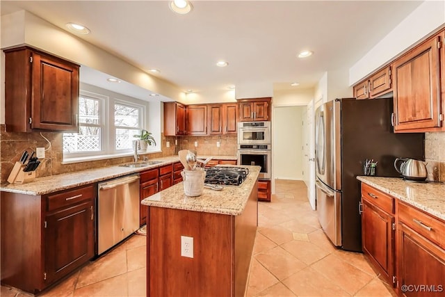 kitchen with light stone countertops, a sink, a center island, appliances with stainless steel finishes, and decorative backsplash