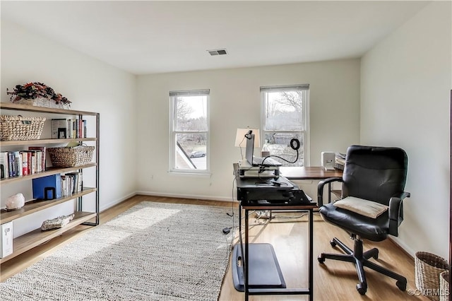 office with visible vents, baseboards, and wood finished floors