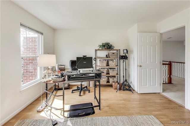 office with light wood finished floors and a wealth of natural light