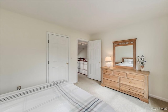 bedroom with light carpet and baseboards