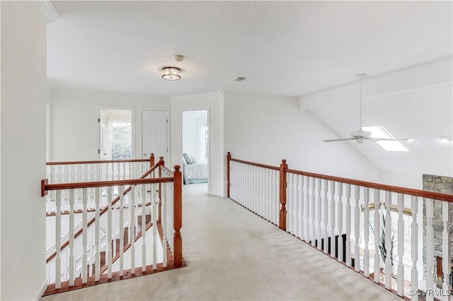 hallway featuring carpet flooring, vaulted ceiling with beams, and an upstairs landing